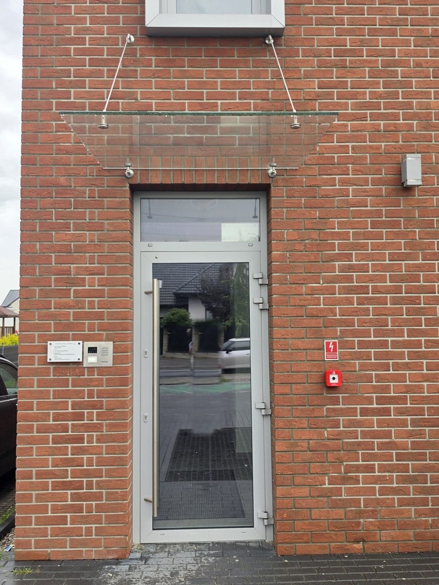 Wejście do budynku przy ul. Szkolnej 10A w Lesznowoli, drzwi z domofonem